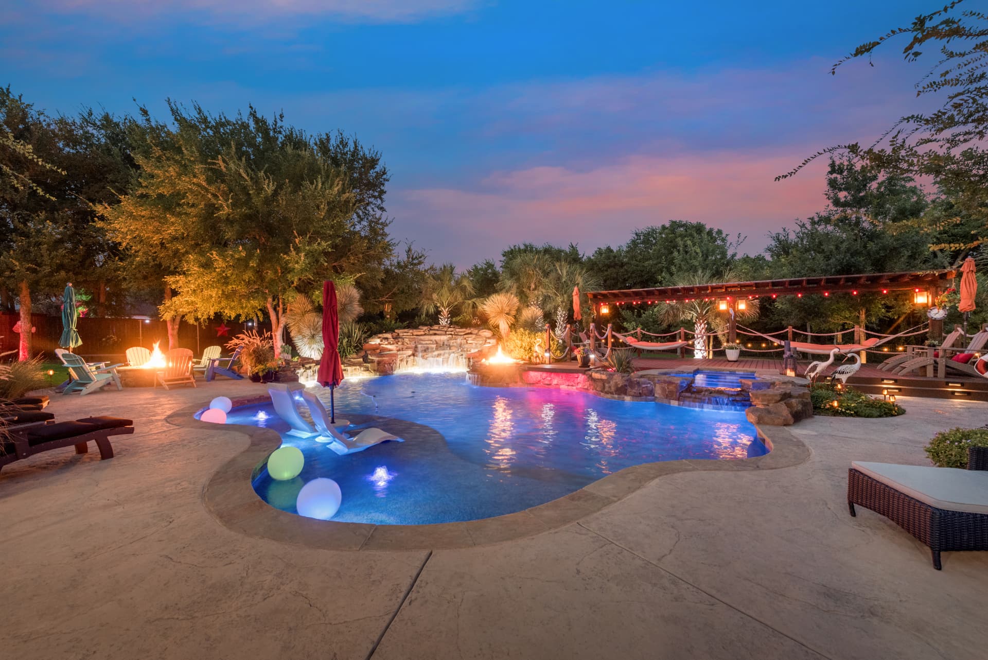 Freeform with fire features and pool lights at dusk