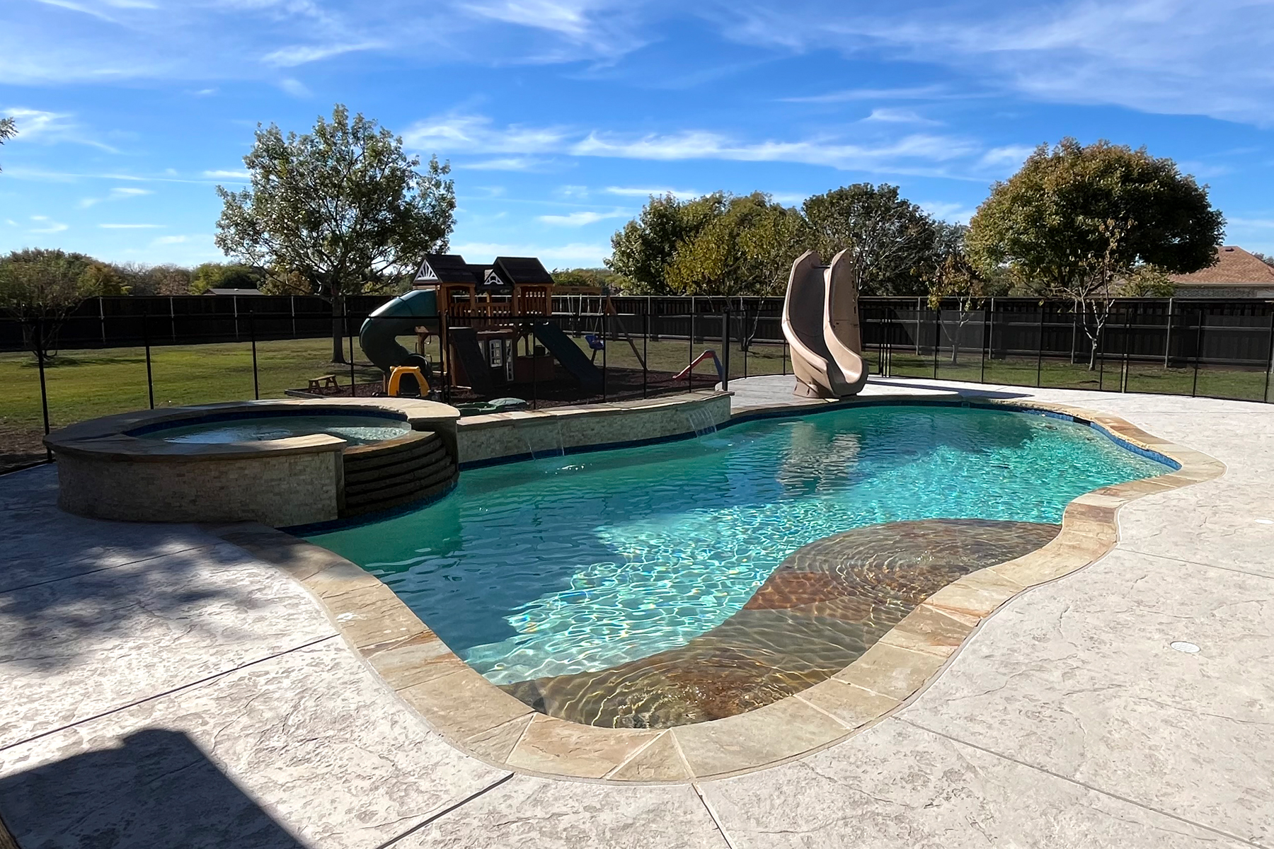 Freeform pool with natural stone and mature trees